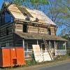 The old roof is covered by the new framing. The underlayment is applied to the sheeting and the roof is readied for the tile.