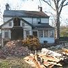 Wayne Wall removes the fallen brick as the two chimneys on the roof a cleared of their modern brick.