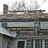 New rafters were installed on the back porch, underlayment and a nylon mesh for air circulation are laid down. Then the shingles are trimmed to fit and nailed.